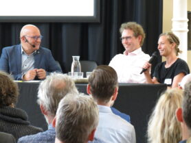 Simon Tindemans (TU Delft; midden) en Janna de Graaf (Universiteit Utrecht; rechts) in gesprek met Gert-Jan Jansen (links)
